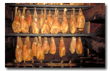 hams hanging in a smokehouse